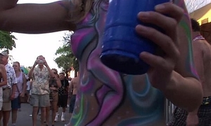 body painted and flashing girls during the day at mardi gras like festival